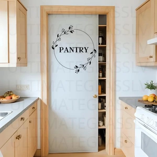 Pantry door with etched glass circle laurel design in modern kitchen.